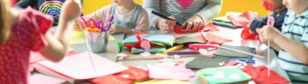 foto en la que aparecen niños y adultos haciendo manualidades