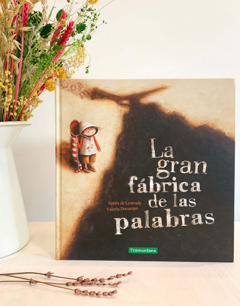 PORTADA DEL LIBRO EN EL QUE APARECE LA SOMBRA DE UNA FÁBRICA Y AL PROTAGONISTA CON UN CAZAMARIPOSAS