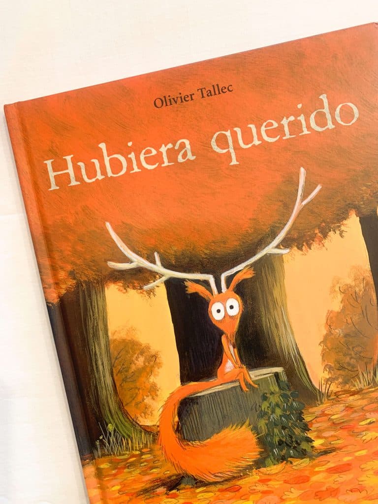 Portada del cuento en la que aparece una ardilla con una cornamenta de ciervo sentada sobre un tocón en un bosque