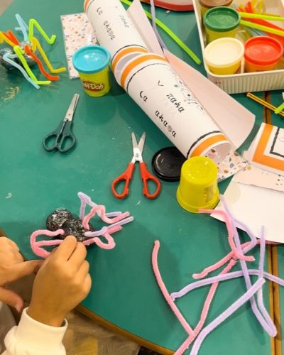 fotografía en la que aparecen detalles de los niños haciendo una araña de plastifica